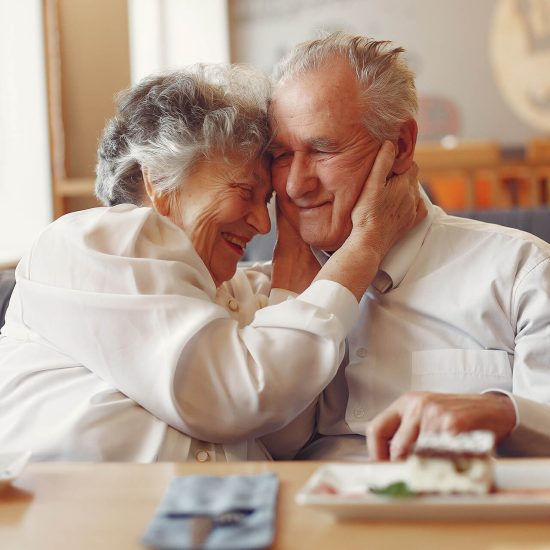 A happy older couple sharing a meal at a table