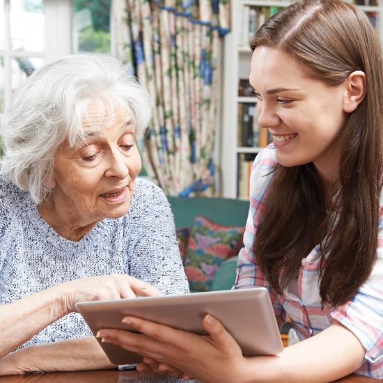 A younger woman sitting with an older woman at home